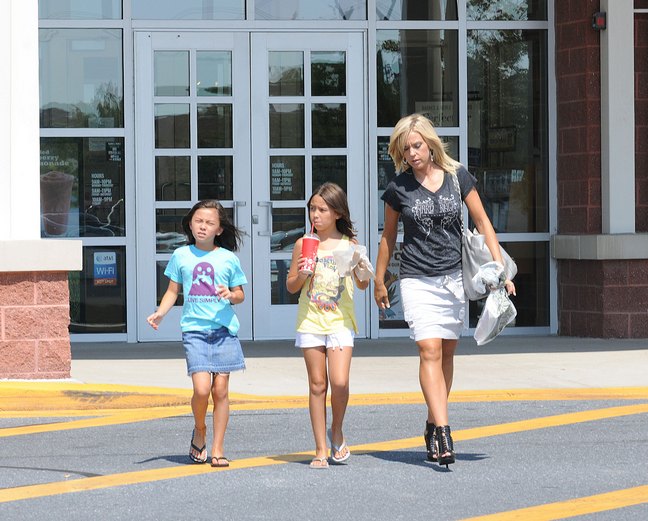 Kate Gosselin, black t shirt, black strappy heels, white mini skirt, silver bag