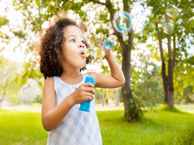 Little girl blowing bubbles