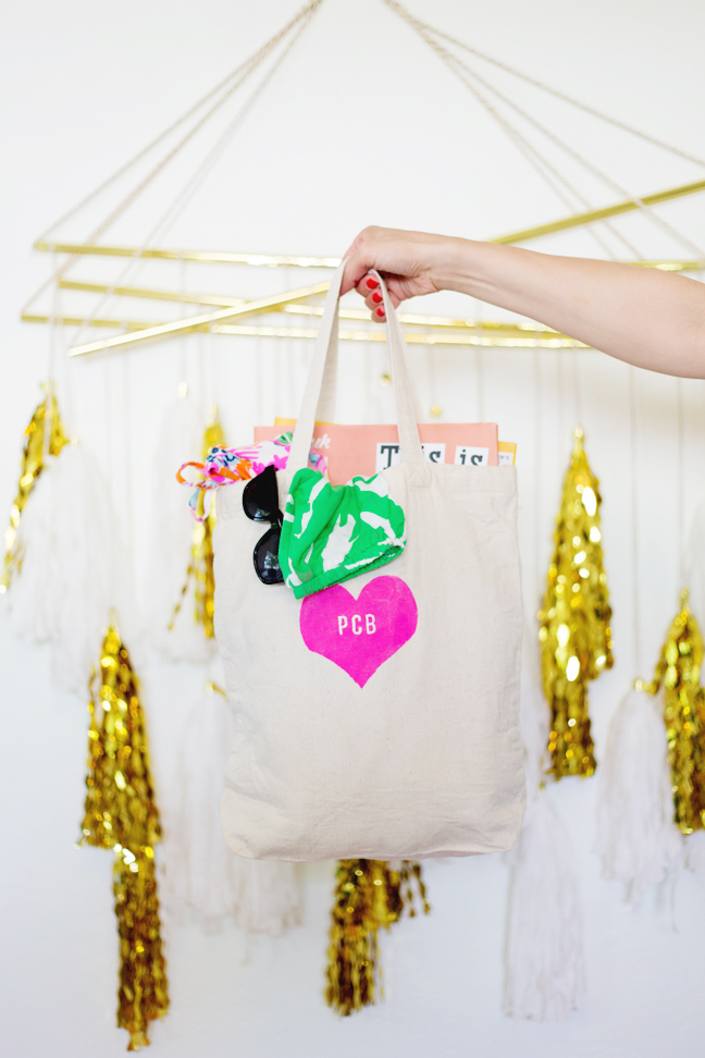 hand-holding-kids-monogrammed-tote-bag-gold-tassels