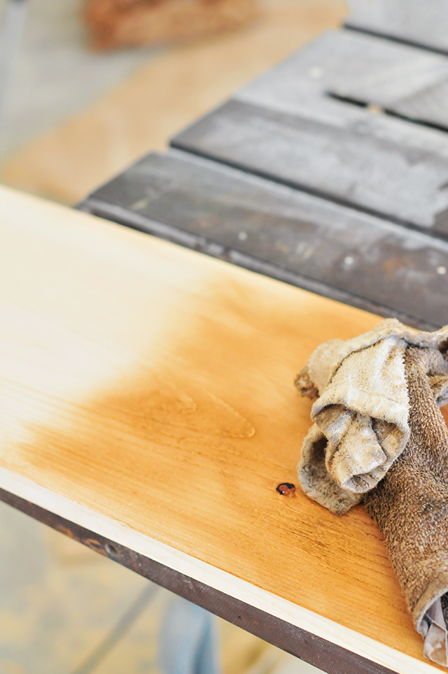 sanding and staining wood to create industrial wall shelves