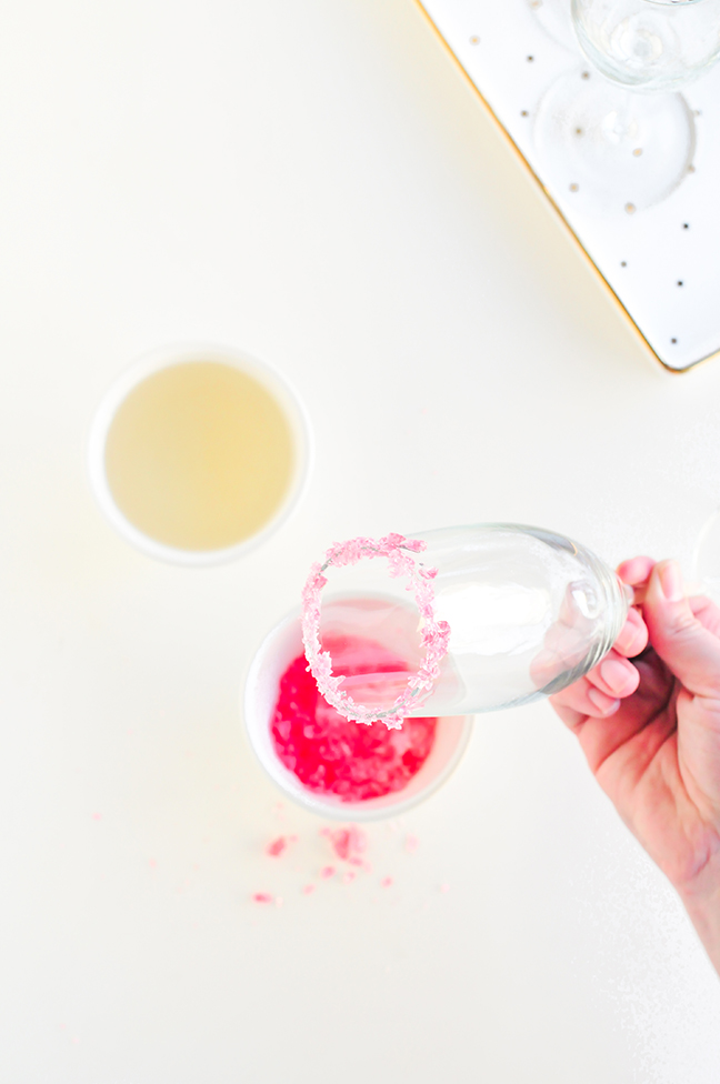 dipping champagne flute in crushed candy