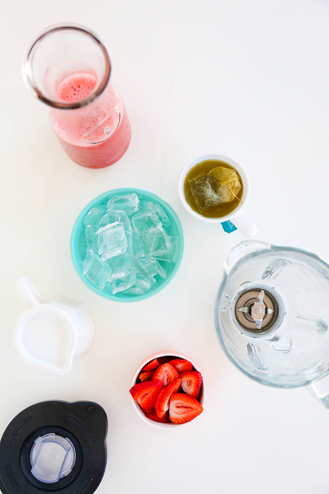 cup with ice strawberries and blender