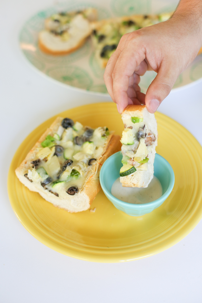 hand dipping pizza in ranch