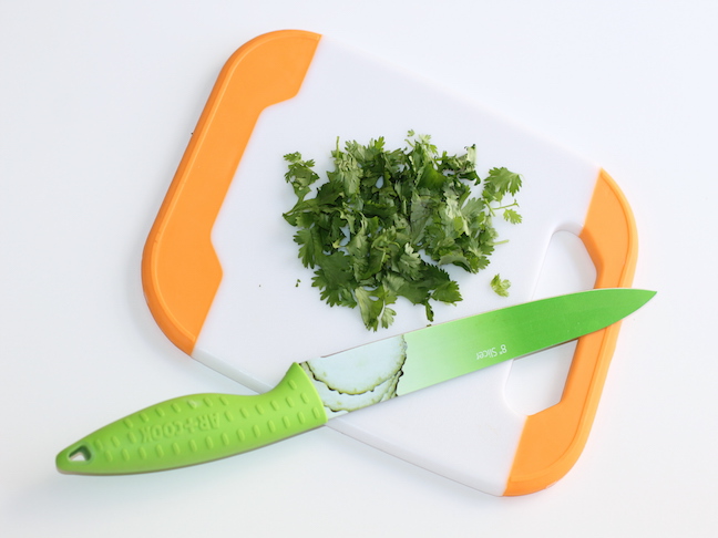 chopped cilantro on cutting board green knife