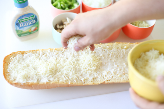 sprinkling cheese on garlic bread