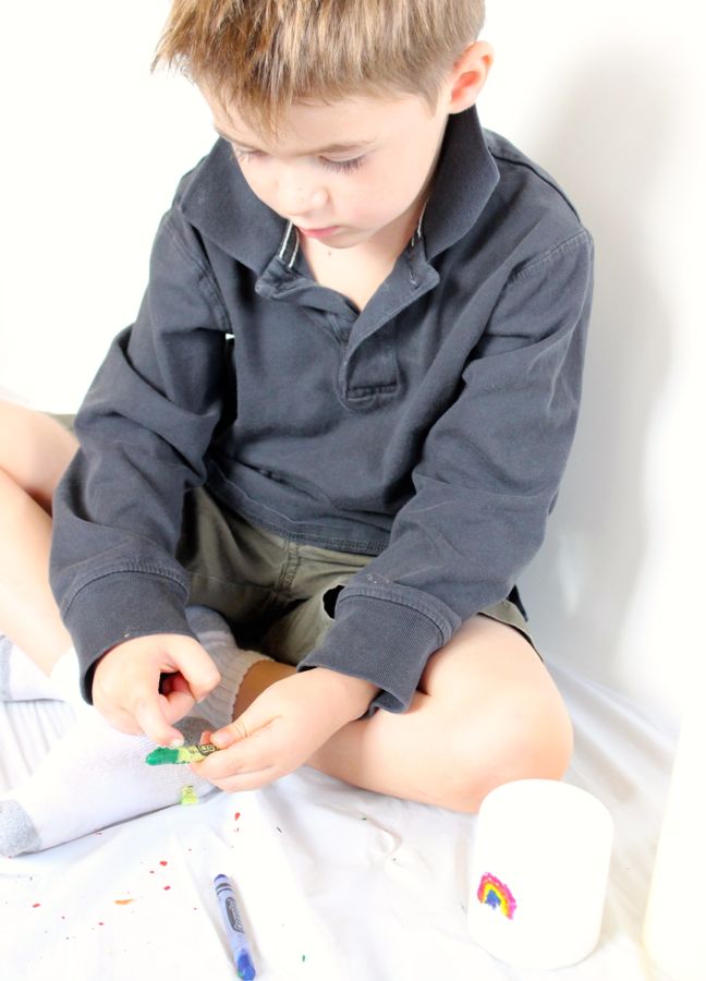 boy peeling paper off crayons