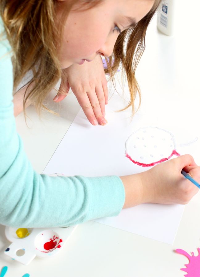 young-girl-painting-with-a-red-ladybug-with-watercolor-paints