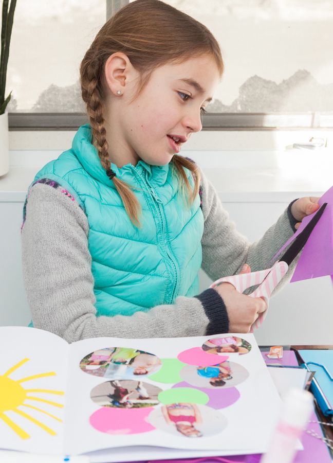 girl-cutting-purple-paper-for-a-scrapbook