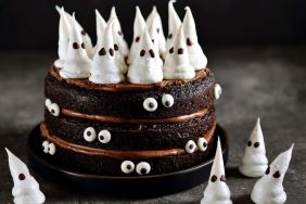 Stock photo of Homemade Chocolate Cake with Chocolate cream and Meringue Ghost and Eyes for Halloween Party.