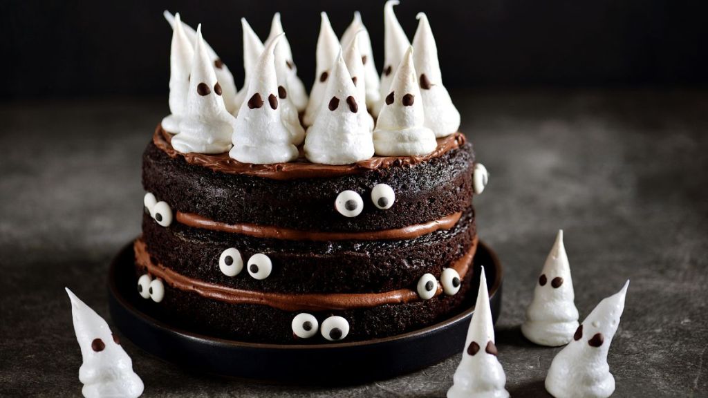 Stock photo of Homemade Chocolate Cake with Chocolate cream and Meringue Ghost and Eyes for Halloween Party.