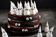 Stock photo of Homemade Chocolate Cake with Chocolate cream and Meringue Ghost and Eyes for Halloween Party.