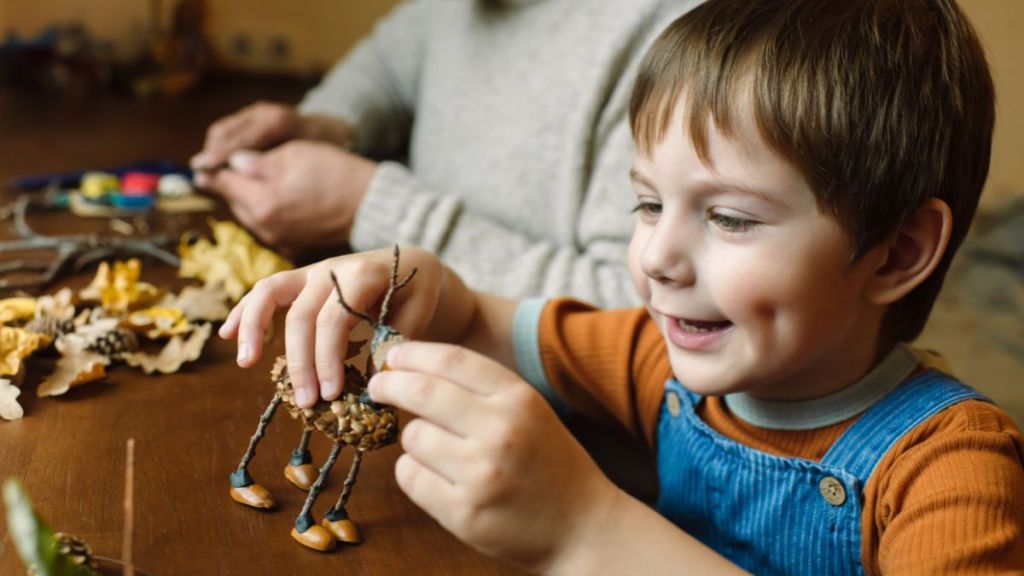 Kid doing DIY craft using pinecone.