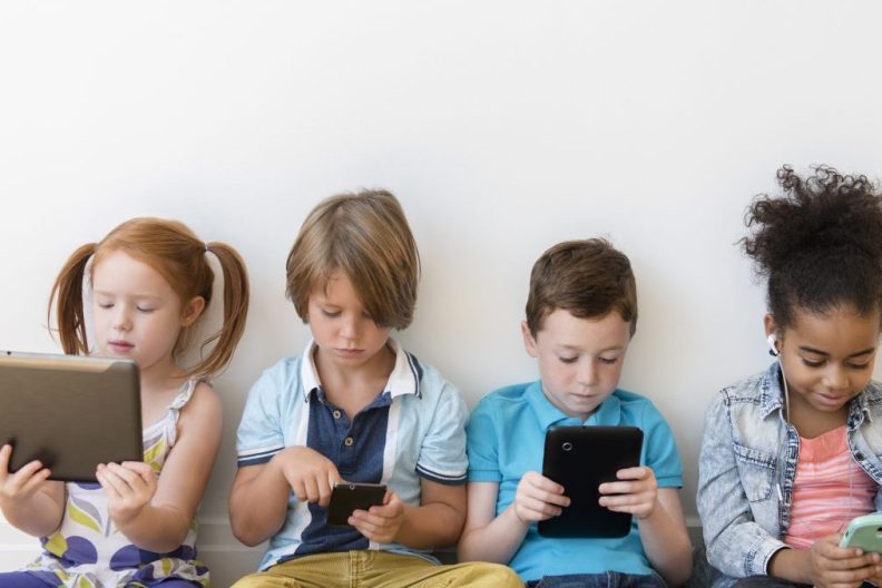 Kids sitting on their gadgets, scrolling through social media, which has now been banned for children under 16 in Australia.