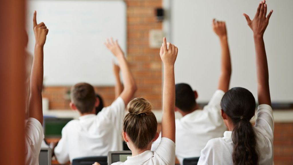 School students in uniforms working with tablets in class