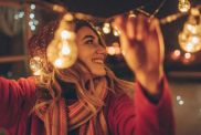 Photo of a young woman who is hosting New Year's party and having the last preparations on the venue - charming balcony over the city