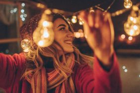 Photo of a young woman who is hosting New Year's party and having the last preparations on the venue - charming balcony over the city