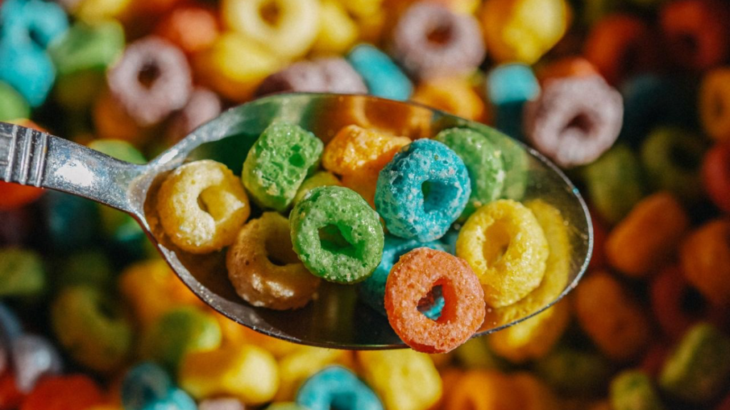 Close up of a spoon filled with colorful loo-shaped cereal